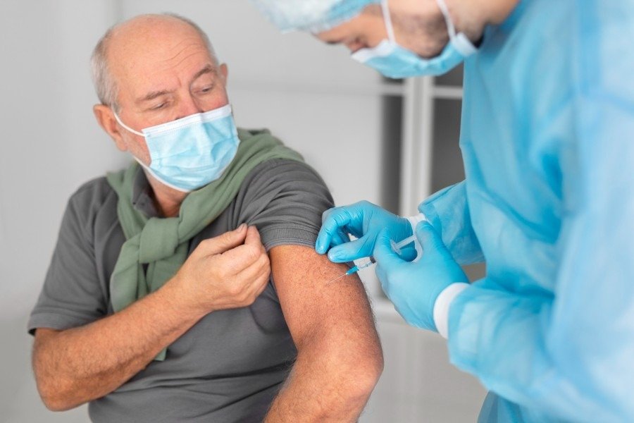 Adult receiving a vaccination from a healthcare professional